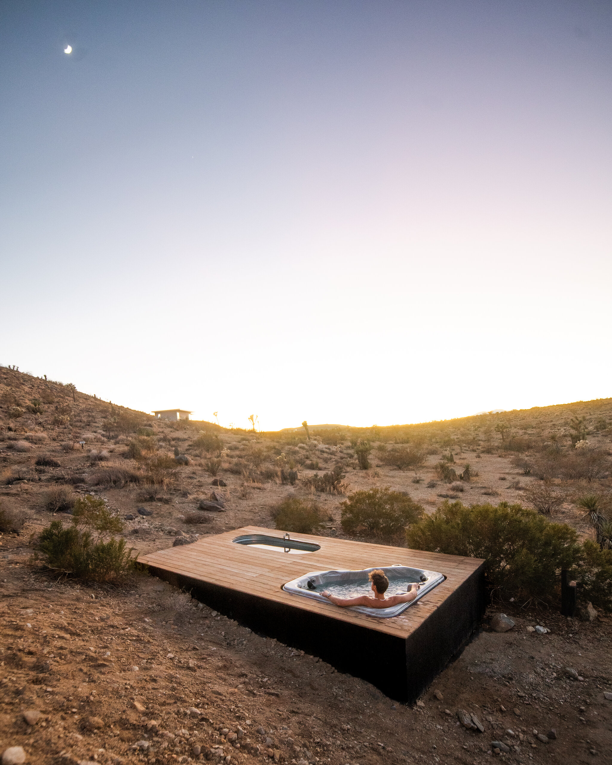 Aerial view of Pause House AM tubs under a golden sky